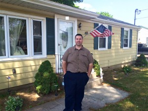 Weatherization client poses outside his home.